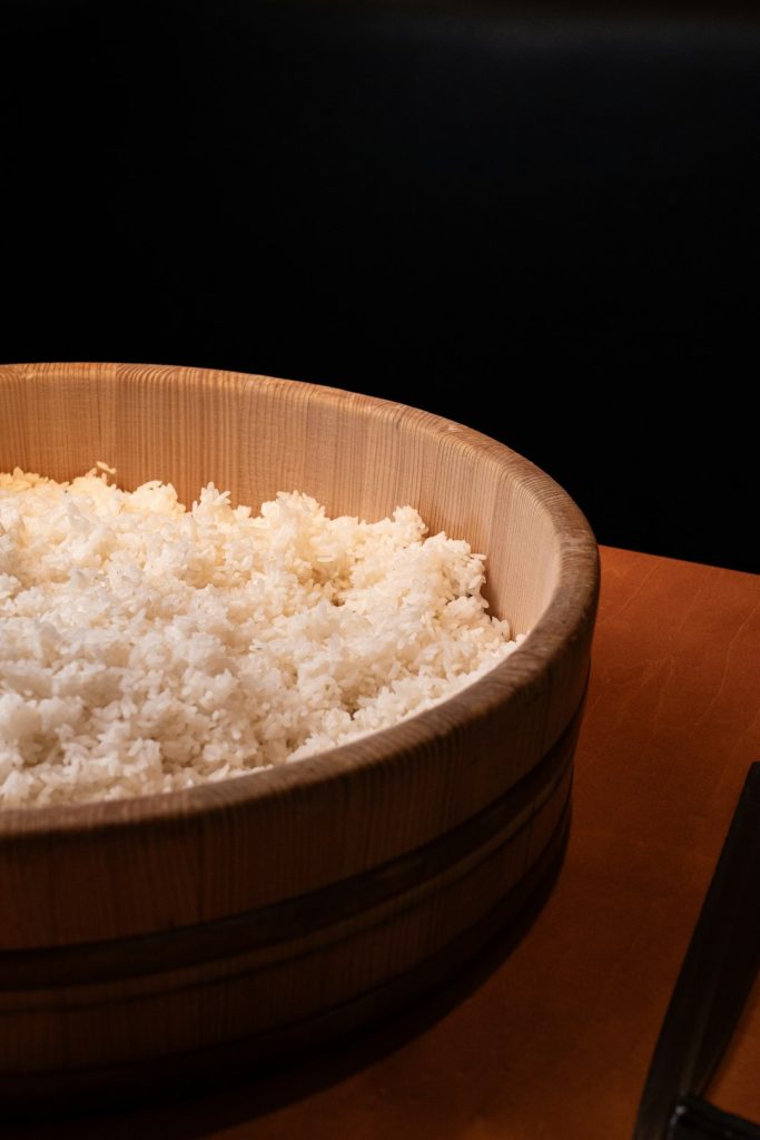 a-wooden-bowl-filled-with-rice-on-top-of-a-table-xwqoky7evdw